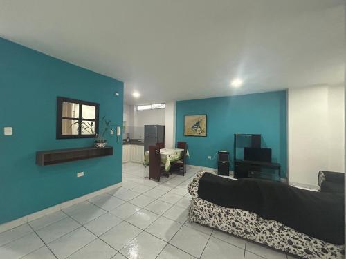 a living room with a couch and a blue wall at Departamentos de 2 y 3 Habitaciones en el Centro de MANTA in Manta