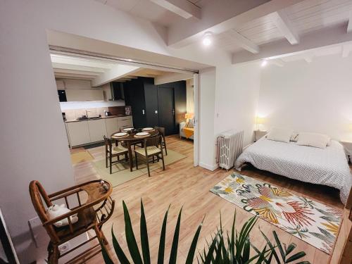 a bedroom with a bed and a table in a room at Calme et Confort sur les Hauteurs de Montauban in Montauban