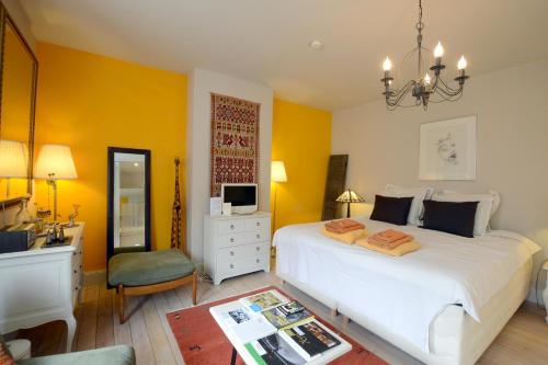 a bedroom with a bed and a desk and a television at R&breakfast in Roeselare