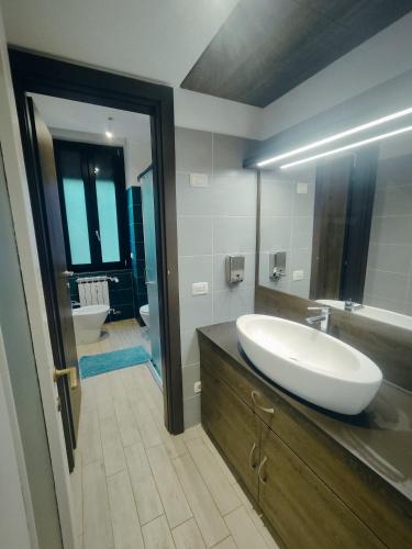 a bathroom with a sink and a large mirror at Cinhouse in Milan