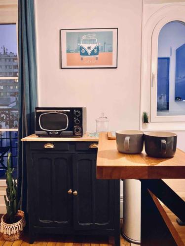 - une cuisine avec un comptoir, un four micro-ondes et une table dans l'établissement Paris 15 - Porte de Versailles, Salon des expositions - Cosy studio, à Paris
