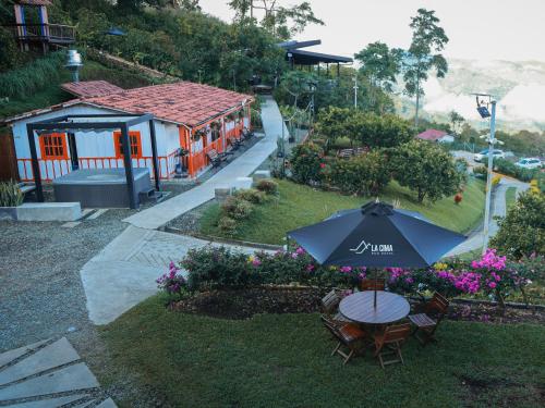 a table and chairs with an umbrella in a yard at La Cima Eco Hotel in Buenavista