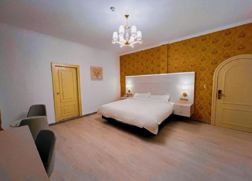 a bedroom with a white bed and a chandelier at Hotel Sucre in Quito