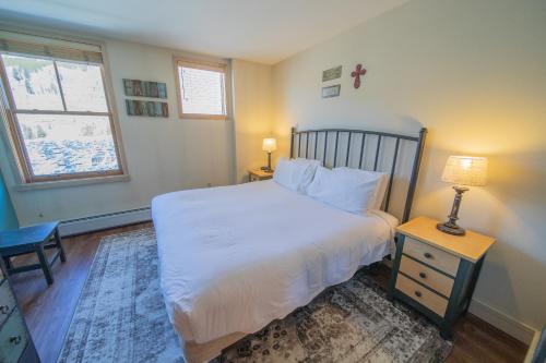 ein Schlafzimmer mit einem weißen Bett und einem Fenster in der Unterkunft Silver Mill 8302 by SummitCove Lodging in Keystone