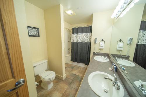 ein Badezimmer mit zwei Waschbecken, einer Toilette und einer Dusche in der Unterkunft Silver Mill 8302 by SummitCove Lodging in Keystone