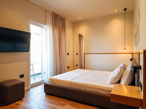 a bedroom with a bed and a large window at Sunset Shoreline Saranda - Sea View - Free Private Parking - Pool in Sarandë