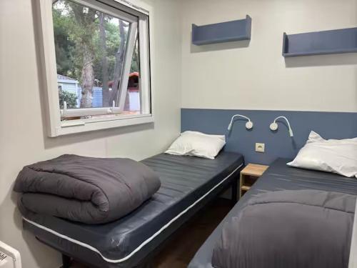 une chambre avec deux lits et une fenêtre dans l'établissement Mobil Home 6 personnes La Marina, à Canet