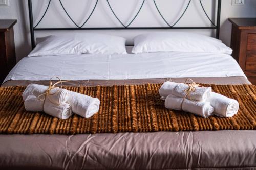 a bed with three rolled up towels on it at ISLAVENTO case vacanza Trapani in Trapani