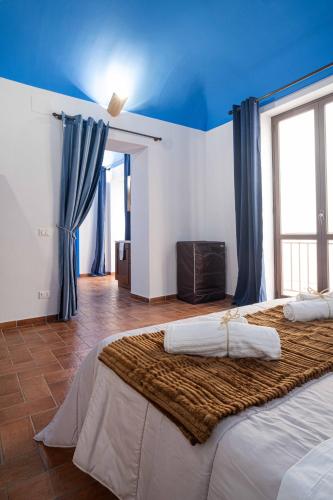 a bedroom with two beds and a blue ceiling at ISLAVENTO case vacanza Trapani in Trapani