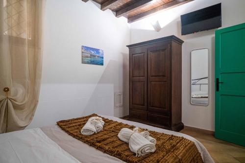 a bedroom with a bed with towels on it at ISLAVENTO case vacanza Trapani in Trapani