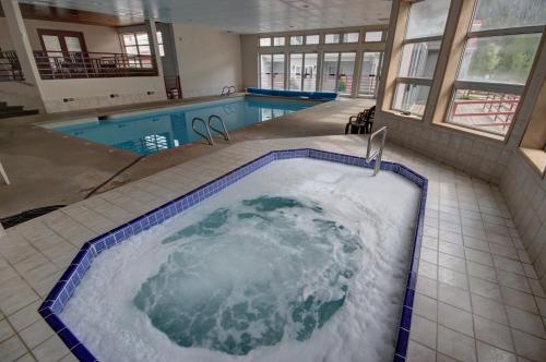 a large jacuzzi tub in a building with a pool at Liftside 203 by SummitCove Lodging in Keystone