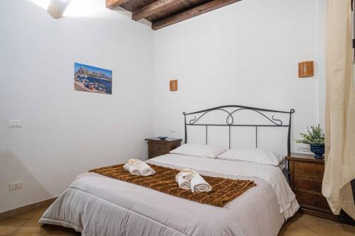 a bedroom with a bed with two towels on it at ISLAVENTO case vacanza Trapani in Trapani