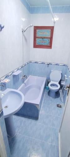 a bathroom with a tub and a toilet and a sink at Blue Horizon Homestay -FOR MEN ONLY- in Dumyāţ al Jadīdah