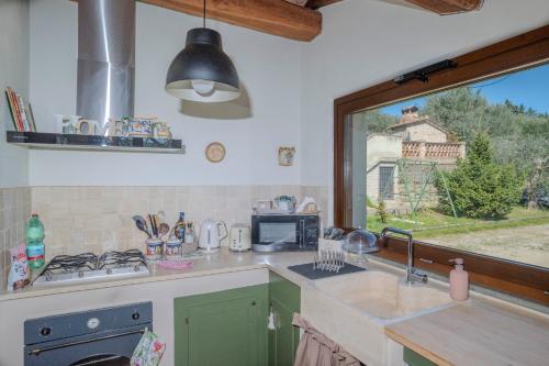 a kitchen with a sink and a window at Cottage La Dolce Agogia Panicale in Panicale