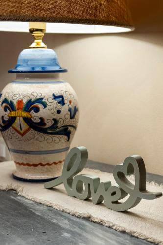 a large vase sitting on a table next to a sign at Cottage La Dolce Agogia Panicale in Panicale