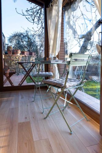 a chair and table in a room with a window at Cottage La Dolce Agogia Panicale in Panicale