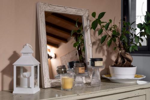 a mirror sitting on top of a counter with a table with a candle at Cottage La Dolce Agogia Panicale in Panicale