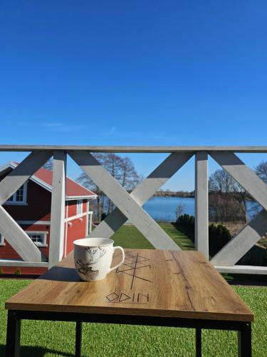a coffee cup sitting on a wooden table on a balcony at GłuszaSpot Dom Odyn in Bytoń