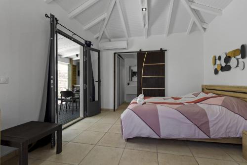 una camera da letto con un letto e una porta scorrevole in vetro di Bungalow Club Océar Love a Le Gosier