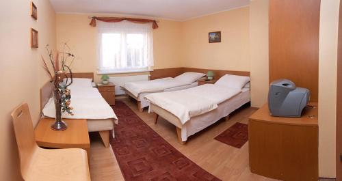 a bedroom with three beds and a window at Dom Gościnny Pod Brzozami in Poznań