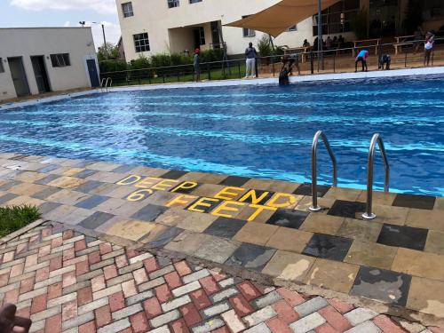 a swimming pool with a sign that reads deep end of peril at RCMRD EXECUTIVE SUITES in Nairobi