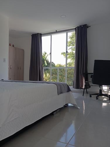 a bedroom with a bed and a large window at MonteClaro de Fusa in Fusagasuga