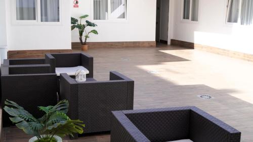 a hallway with black wicker furniture in a building at El Patio Hostal in Alicante