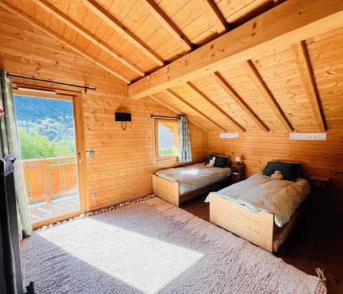 - une chambre avec 2 lits dans une cabane en bois dans l'établissement Chalet Coclico, à Saint-Gervais-les-Bains