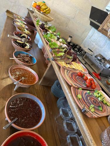 a wooden table topped with lots of different types of food at Gala Cave Cappadocia in Goreme