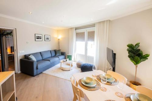 a living room with a table and a blue couch at Supreme 75m2 Two-Bedroom Apartment - VW142 in Eindhoven
