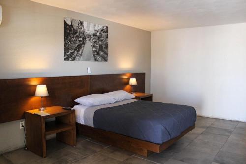 a bedroom with a bed with two night stands and two lamps at Condomino Maripina in Arena