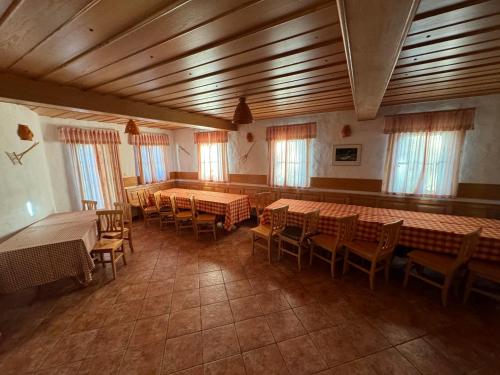 a large room with tables and chairs and windows at Zidanica Jakec in Podlehnik
