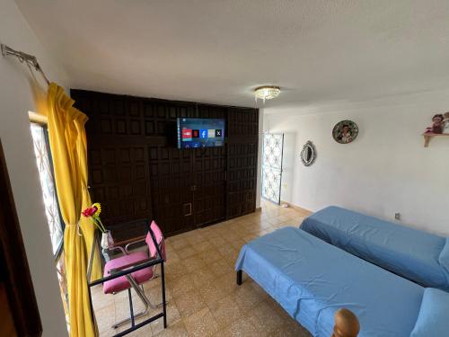 a living room with a blue couch and a tv at Casa Angelitos in Guanajuato