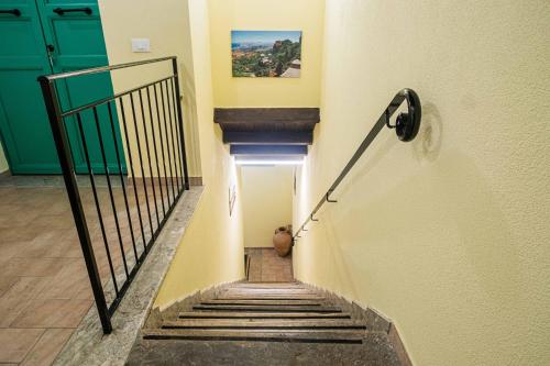 a stairway with a green door and a stair railing at ISLAVENTO case vacanza Trapani in Trapani