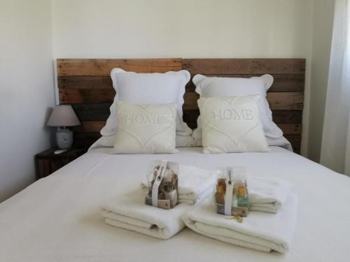 a white bed with two towels and two pillows at PRIMERA LINEA de PLAYA SAN JUAN en ALICANTE in Benimagrell