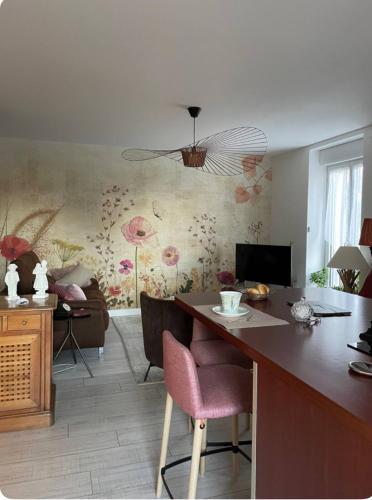 a living room with a kitchen with a table and chairs at Chambre cosy aux Sables Blancs in Douarnenez
