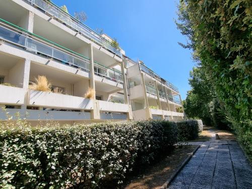 un immeuble d'appartements avec des buissons devant lui dans l'établissement Les Dryades 4 pax appartement, à La Baule
