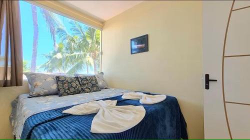 a bedroom with a bed with towels on it at Home Beach in Maragogi