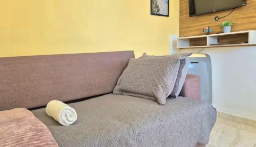 a couch with a pillow on it in a room at Home Beach in Maragogi