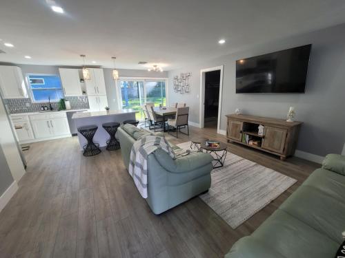 a living room with a couch and a table and a kitchen at Jungle in the City! in West Palm Beach