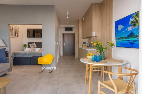 a kitchen and living room with a table and a bed at Apartamenty Boszkowo Aquarius Blue in Boszkowo