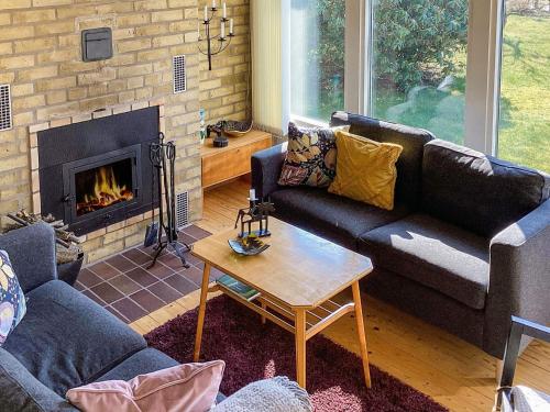 a living room with couches and a fireplace at 4 star holiday home in SKÅNE VEJBYSTRAND in Vejbystrand