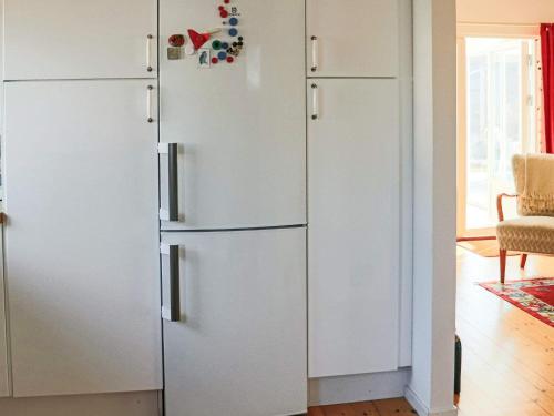 a white refrigerator in a kitchen next to a door at 4 star holiday home in SKÅNE VEJBYSTRAND in Vejbystrand