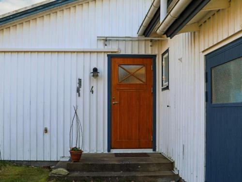 a wooden door on a white building with a blue door at 4 star holiday home in SKÅNE VEJBYSTRAND in Vejbystrand