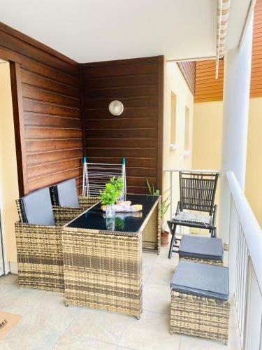 un patio avec des chaises en osier et une table dans l'établissement A perfect apartment in Capbreton center, à Capbreton