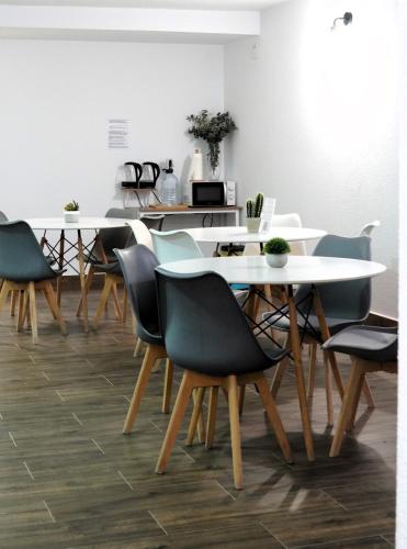 a dining room with white tables and chairs at El Patio Hostal in Alicante