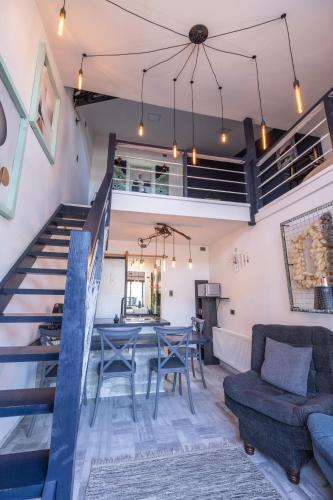 a living room with a table and chairs and a staircase at Okeyloft, Coyhaique 2 in Coihaique
