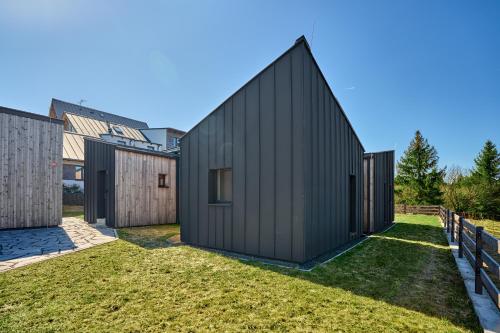 a black house with a pointed roof at Chalet Popcorn by Mountain ways in Abertamy