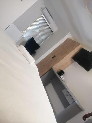 a room with a bed with a desk and a window at Gold Rush Oasis in Johannesburg