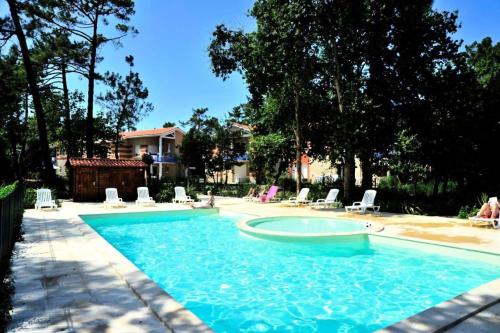 - une piscine avec des chaises longues dans la cour dans l'établissement Résidence Villa Marine - 021- Bel appartement avec son jardin privatif MAE-1841, à Soulac-sur-Mer